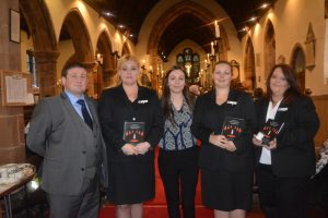 5 people stand inside St Edburghas Church for the Christmas remembrance service.