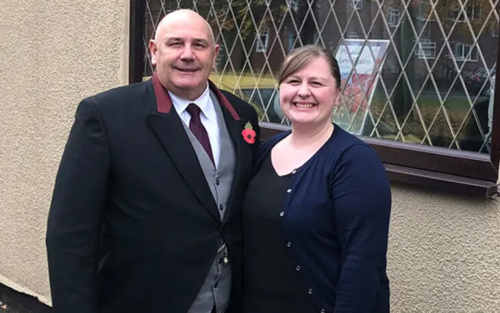 Clive and Lesley stand in front for window at Turners Funeral Service.