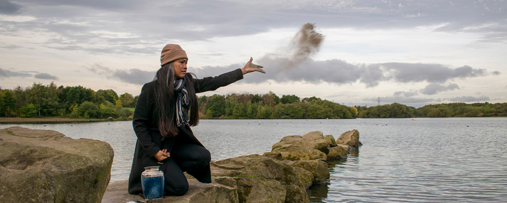 Woman scattering ashes in water after a direct cremation