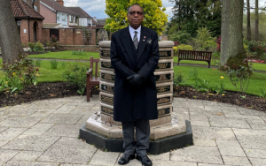 Picture of Sam Bryan standing in front of memorial.