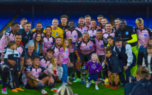 Picture of various celebrities posing in pink football kits for charity.