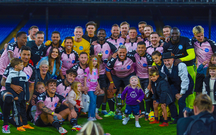 Picture of various celebrities posing in pink football kits for charity.