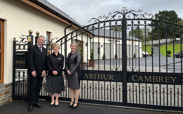 A group of people standing in front of a black iron gate.