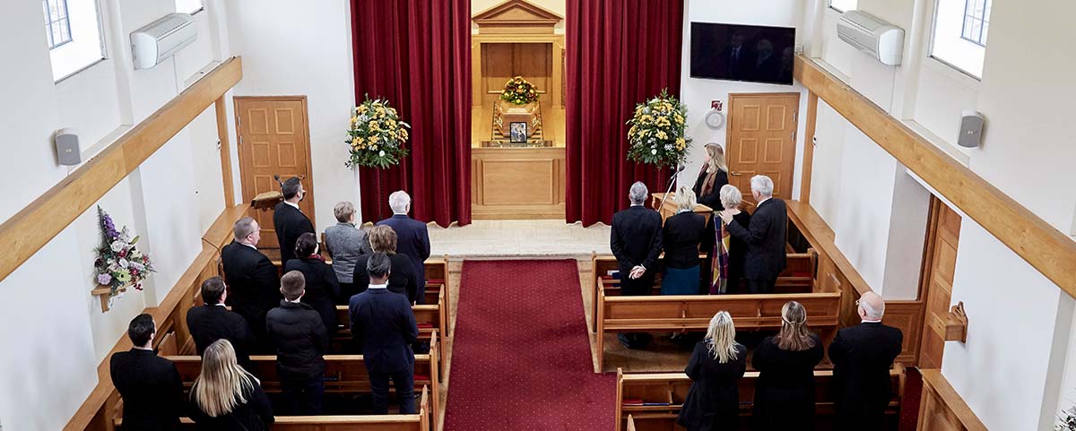 High view of a funeral service showing mourners and celebrant