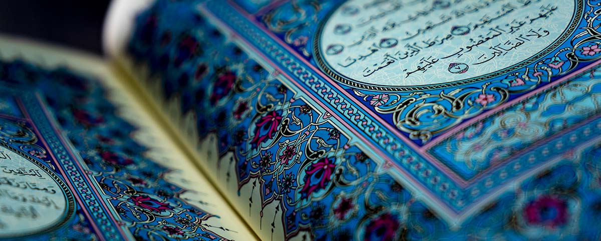 Close up image of the Qur'an with blue pattern decorations