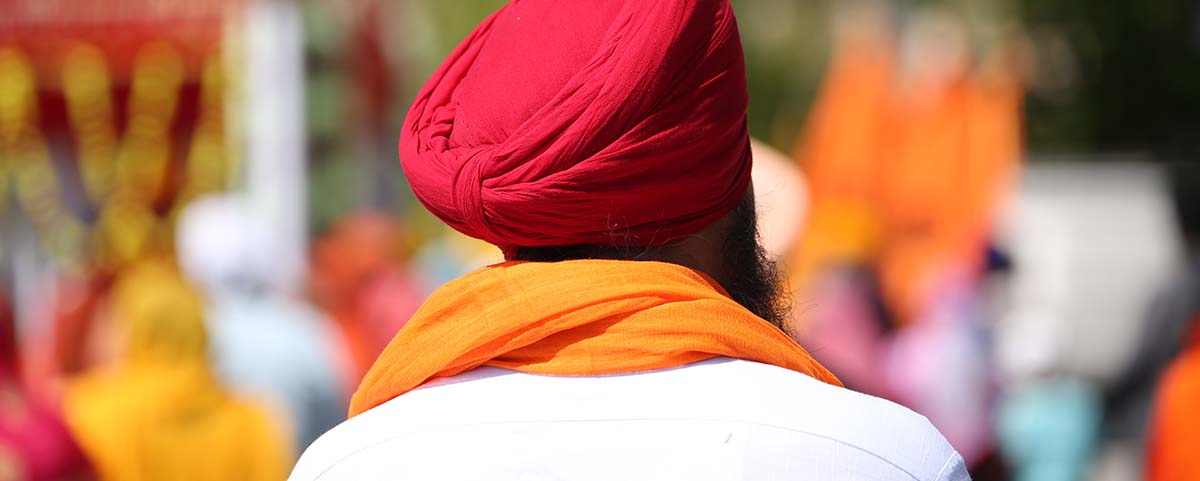 A Sikh man with traditional orange and red outfit