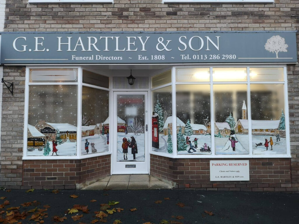 Front of G.E. Hartley & Son Funeral Directors with Christmas windows