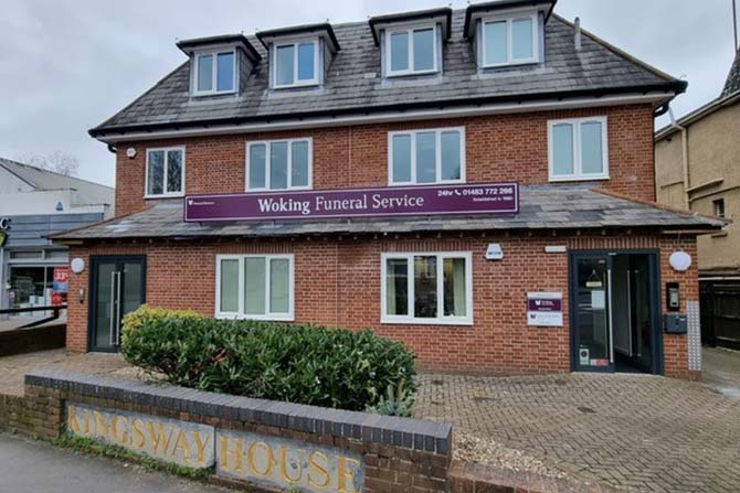 Front of Woking Funeral Service in Woking showing face brick building with purple signs